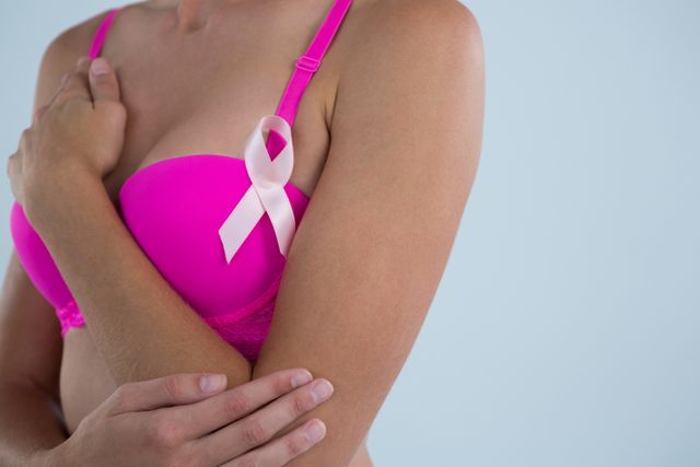 Woman with Breast Cancer Awareness ribbon touching hand - Download Free Stock Photos Pikwizard.com